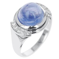 a ring with a large blue stone surrounded by diamonds