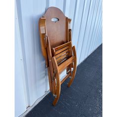 a wooden rocking chair against a white wall