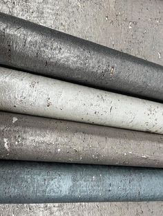 several different types of pipes stacked on top of each other in an area with concrete flooring