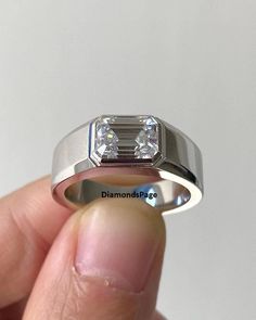 someone is holding a diamond ring in their left hand and it looks like they have two diamonds on each side