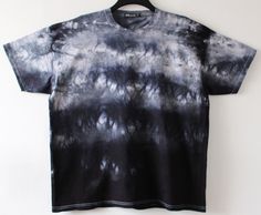 a black and white tie - dye shirt hanging on a wall