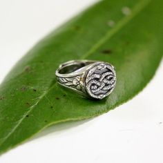 This AURYN originated from the cult movie "The Neverending Story". My Auryn ring is cast in solid sterling silver that has been gently oxidized to enhance the detail of the entwined serpents.  The adjustable band is adorned with a pair of floral clusters and is available up to a size ten.Matching earrings are available herehttps://www.etsy.com/listing/235640002/auryn-earrings-in-solid-sterling-silverALTERNATIVE FINISH: Bronzehttps://www.etsy.com/listing/237362155/auryn-necklace-in-solid-bronze40 Silver Etched Signet Ring, Silver Oxidized Finish Signet Ring As Gift, Etched Silver Signet Ring For Promise, Sterling Silver Signet Ring With Oxidized Finish, Oxidized Sterling Silver Signet Ring, Hand Forged Sterling Silver Signet Ring For Anniversary, Etched White Gold Sterling Silver Signet Ring, Sterling Silver Etched Jewelry For Promise, Antique Silver Engraved Ring With Oxidized Finish For Anniversary