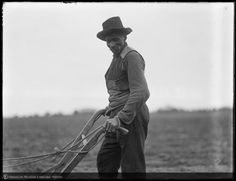 an old black and white photo of a man plowing