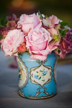 some pink roses are in a blue vase