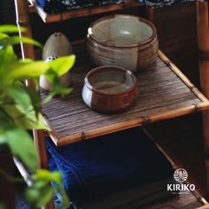 a bamboo shelf with two bowls on it and some other items sitting on top of it