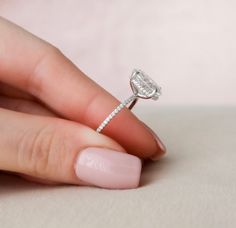 a woman's hand holding a diamond ring