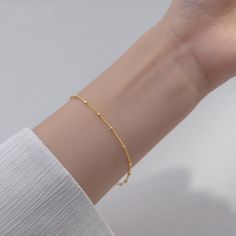 Our lightweight Minimal Satellite Chain Bracelet brings a fresh feel to your wardrobe. Simple and shimmery, this bracelet begs to be layered with others but can be worn alone for a minimal, polished look. DETAILS & SIZE Finish: 18K gold or rose gold plate, Sterling silver Material: .925 sterling silver Measurements: Beads: 2mm; Chain: 7" Lobster claw clasp Shop Bracelets for more options to layer it with! Complete the Look with the Matching Necklace! Minimalist Gold Chain Bangle Bracelet, Simple Gold Bracelet With Adjustable Chain, Simple Bracelets With Adjustable Chain, Simple Design Gold Bracelets For Everyday, Gold Bracelets With Simple Design For Everyday, Delicate Everyday Chain Bracelet With Simple Design, Modern Bracelets With Satellite Chain, Modern Satellite Chain Bracelets, Minimalist Delicate Chain Bangle Bracelet