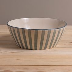 a striped bowl sitting on top of a wooden table