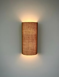 a wall mounted light with a fabric shade on it's back end and side