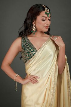 Embrace the beauty of the Cassandra Cream Satin Gold Trim One Minute Saree made with a gold sequin border. Styled with a art silk blouse in bottle green color. Perfect for your next festive occasion. Product Features: Saree Color: Cream Blouse Color: Bottle Green Saree Fabric: Satin Blend Blouse Fabric: Art Silk Blouse In Green Saree Work: Gold Sequin Border Saree Wash Care: Dry Clean Occasion: Party , Cocktail Party ,Wedding Reception Package Content: Saree Disclaimer: There will be slight diff Sleeveless Silk Traditional Wear For Party, Green Pre-draped Saree For Diwali Celebration, Elegant Green Pre-draped Saree For Celebration, Gold Pre-draped Saree For Navratri Party, Green Sleeveless Traditional Wear For Wedding, Sleeveless Green Traditional Wear For Wedding, Sleeveless Green Traditional Wedding Wear, Gold Pre-draped Saree With Cutdana For Party, Gold Bollywood Pre-draped Saree For Celebration