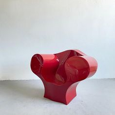 a red sculpture sitting on top of a white floor next to a wall and window