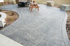 an outdoor patio with a grill and picnic table