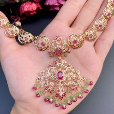 Featuring an elegant rajasthani necklace set crafted in 22ct gold and embellished with precious pearls, rubies and emeralds. The necklace weighs 27.16 GMs including 1.77 GMs of hanging ruby emerald beads and the earrings weigh 17.10 GMs including 2.82 GMs in hanging ruby emerald beads. This unique set is sure to make a dazzling statement. Each piece is carefully crafted with attention to detail, making this set an heirloom-quality item. Price Breakup Summary Component Rupees % of Total 22k Gold Traditional Gold Plated Necklaces With Jewels, Traditional Gold Emerald Necklace With Jewels, Ruby Temple Jewelry Set, Yellow Gold Ruby Kundan Necklace In Temple Jewelry Style, Yellow Gold Kundan Necklace With Ruby In Temple Style, Festive Hand Set Emerald Pendant Necklace, Traditional Ruby Bridal Necklace With Gemstones, Traditional Ruby Gemstone Bridal Necklace, Ruby Gemstone Bridal Necklace For Festivals