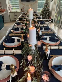 the table is set with candles, plates and napkins for dinner guests to enjoy