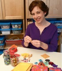 a woman sitting at a table with some food in front of her and other items on the table