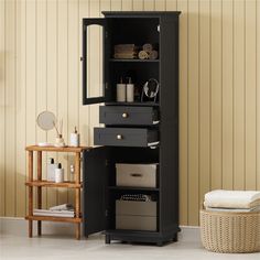 a bathroom with a black cabinet and white towels on the floor next to a basket