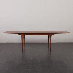 a wooden table sitting on top of a cement floor