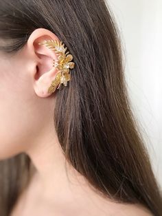 Gorgeous modern style ear cuff decorated with delicately shaped leaves. You can use our ear cuff on the right or left side.  Has a rode metal soldered on the back of it that could be  opened for an easy wear or squeezed inwards for a secure fit. The set includes a mini zirconium stud earring for the second ear VAT: Value Added Tax (VAT) is a tax that is charged when your parcel reaches the destination country. You may be required to pay VAT in order to receive your parcel. Customs policies and import duties vary widely from country to country, and we have no control over these charges. As a guide: USA: from 800 USD UK: 20% EU: 15% CUSTOM ORDERS If you liked the product, but you want to make your own changes, color / length / use of other beads. Please tell me about it in a personal message Elegant Adjustable Gold-plated Ear Cuff, Elegant Adjustable Gold Plated Ear Cuff, Gold Plated Ear Cuff For Wedding, Yellow Gold Ear Cuff For Wedding, Gold Delicate Pierced Ear Cuff, Delicate Gold Pierced Ear Cuff, Delicate Gold Pierced Ear Climbers, Delicate Gold Ear Climbers, Elegant Adjustable Ear Climbers For Party