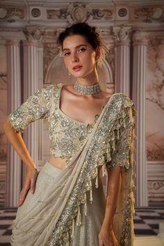 Step into glamour with this exquisite gray sari, crafted from luxurious sequined fabric. The heavy skirt provides a stunning foundation, while the draped pallu is fully embroidered, featuring beautiful long tassels that add a playful touch. The padded blouse ensures a flattering fit, making this ensemble perfect for grand occasions where elegance and sophistication are essential. Embrace the allure of this captivating outfit, designed to make a lasting impression. Sequence Fabric, Skirt Saree, Sequence Skirt, Sequined Fabric, Sari Skirt, Sequined Skirt, Beaded Work, Tuxedo Accessories, Grey Saree