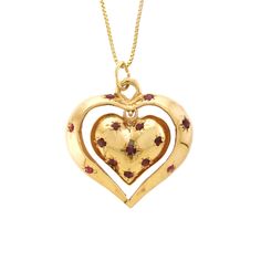 "This charming 14k yellow gold and Ruby pendant features two articulating hearts, both fashioned into a dome with a solid flat back. The inside heart is bead set with eight round Rubies; the inside heart dangles inside the center of the larger open heart, which has six bead-set, round Rubies. Perfect sentimental gift for your heart throb!   -  14k yellow gold  -  Outer Heart (frame): 1.13\" x 1.03\" x .17\" (28.80 wide x 26.30 long x 4.50mm deep) -  Inside Heart: .70\" x .63\" x .23\" (18.00 wide x 16.00 long x 5.80mm deep) -  Rubies: 14/0.03 to 0.06ct each, 0.62ctw (estimated due to mounting) -  Ruby color: Medium dark, very slightly brownish, slightly purplish red (slpR 6/3).  -  18\" Box Chain: 14k yellow gold (stamped), spring ring closure, .90mm wide  -  Total Weight: 10.34 grams comp Antique Yellow Gold Heart Cut Jewelry, Elegant Yellow Gold Heart Necklace With Charms, Heirloom Heart Pendant Jewelry For Formal Occasions, Heirloom Style Heart Pendant Jewelry For Formal Occasions, Valentine's Day Pendant Jewelry With Polished Finish, Valentine's Day Polished Pendant Jewelry, Antique Heart-shaped 14k Gold Necklace, Antique Heart-shaped Yellow Gold Jewelry, Yellow Gold Jewelry Stamped 14k With Double Heart