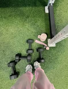 there is a pair of pink shoes next to some dumbbells on the grass