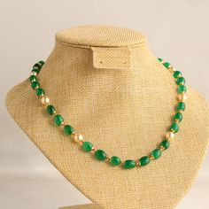 This elegant necklace features exquisite green quartz beads paired with lustrous pearls, creating a stunning combination. The addition of gold beads interspersed between the quartz enhances the piece's sophistication, while decorative caps at both ends of the beads add a touch of refinement.  Versatile in style, this necklace complements all shades of light-colored attire effortlessly. For a complete look, pair it with matching green stone stud earrings for a touch of coordinated elegance. Lengt Elegant Green Oval Bead Necklaces, Elegant Green Onyx Beaded Necklaces, Gold Jade Necklaces With Polished Beads, Elegant Green Necklaces With Oval Beads, Elegant Green Oval Beaded Necklaces, Elegant Green Onyx Bead Necklaces, Gold Jade Beaded Necklaces With Gemstone Beads, Gold Jade Beaded Necklaces With Gemstones, Gold Jade Gemstone Beaded Necklaces