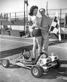 a man and woman standing next to each other on a tennis court holding an american flag