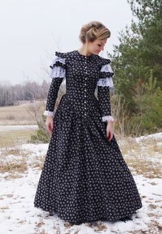 Hazel is a charming dress, with turn-of-the-century styling, and has high neckline with front button closure. Attractive long fitted sleeves have four flounces with alternating lace and cotton print at the shoulder. The 3-paneled skirt with pockets is gathered to the bodice. An attached cascading half-skirt in back adds a bit of a bustle flare to the dress. This dress is truly a delight! Hand wash or machine wash cold gently. Tumble dry low or hang dry. 100% cotton. Ally is wearing a crinoline and boots which are priced separately. Designed and made proudly by Recollections in America!  The following are approximate finished measurements and include room for ease of movement.  BustWaist (in inches) XS36.528 S39        29.5 M41        31.5 L45        35.5 XL49        41 XXL51        44 3XL5 1883 Dress, Fitted Victorian Dress With Buttons, Fall Fitted Victorian Dress With Ruffles, Winter Victorian Dress With Ruffles And Long Sleeves, Victorian Long Sleeve Dress With Historical Design, Victorian Style Dresses For Fall, Black Long Sleeve Regency Dress, Historical Victorian Dress With Buttons, Fitted Victorian Dress With Lace Collar And Long Sleeves