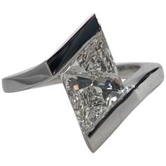 a white gold ring with a princess cut diamond set in the center and black onyx accents