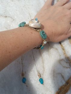 Beautiful Natural Shell Hemp Macrame Bracelet, Macrame Shell Turquoise Boho Bracelet, upcycled paper bead shell adjustable bracelet, beach boho chic... For this beautiful spiral Seashell hemp Macrame beaded Bracelet, I used a unique mix of media... This is a one-of-a-kind jewelry piece. . .. A spiral sea shell that I found on the beach here in Santa Cruz, California is woven into hemp macrame cord with genuine Kingsman turquoise, hand made and laquered (upcycled calendar) paper art beads, vintage glass teal seashell beads and pearlized white beads. I wove all of them together by hand knotting hemp into this adjustable macrame bracelet.  Lanyard style closure will slide to adjust to fit most wrists. At its smallest it measures 7.5 inches long, and at its largest it measures 10 inches. Very Bohemian Bracelet With Adjustable Cord, Turquoise Bohemian Braided Bracelet For Gift, Turquoise Bohemian Braided Bracelet Gift, Bohemian Turquoise Macrame Friendship Bracelets, Turquoise Bohemian Macrame Friendship Bracelets, Turquoise Bohemian Strand Friendship Bracelets, Handmade Bohemian Turquoise Friendship Bracelets, Bohemian Hand Wrapped Turquoise Braided Bracelets, Bohemian Beaded Strand Friendship Bracelets