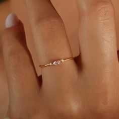 a woman's hand with a diamond ring on top of her finger and the other hand holding it