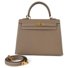 This 100% authentic Hermès Kelly 25 Sellier bag in Etoupe (taupe) Veau Epsom leather is a timeless classic. Featuring elegant contrasting white stitching and gold-plated hardware, it embodies sophistication and understated luxury. The structured design is lined in luxurious Chèvre (goat skin) and includes an open pocket against the front and a zipper pocket against the back for practical elegance. A true icon of Hermès craftsmanship, this bag is a refined addition to any wardrobe. Has been carri Hermes Kelly Bag 25, Kelly 25 Hermes, Kelly Bag Hermes, Hermes Etoupe, Birken Bag, Kelly 25 Sellier, Top Designer Handbags, Hermes Kelly 25, Kelly 25