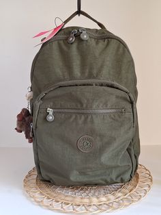 Kipling Seoul Large Backpack, Jaded Green Tonal ~~  This practical full-size backpack is equipped with a padded sleeve for tablet or small laptop and additional interior space w/ three zippered compartments & small zip pocket on top  ~~ Approximately 17"h x 13"w x 7.25" *  Large Zip Pocket - padded sleeve and deep drop pocket *  Secondary Zip Pocket - two slip pockets & pen holder *  Front-facing Zip Pocket - additional storage space *  Small Zip Pocket on top of backpack - storage for keys and/or monetary items... *  Top handle *  Adjustable padded backpack straps *  Furry monkey key chain *  Durable polyester fabric & taupe interior lining Shipping is available to all 50 states and to U.S. Territories Shipping costs are determined by actual weight of packaged item and will vary by locati Green Backpack With Pockets, Green Backpack With Multiple Pockets, Student Green Backpack With Zipper Pocket, Cute Backpacks For College, Green Backpack With Zipper Closure, Kipling Seoul Backpack, Converse Backpack, Kipling Backpack, Aesthetic Backpack