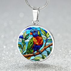 Capture the vibrant beauty of the Rainbow Lorikeet with this stunning pendant necklace. The intricate design showcases the bird's multicolored plumage in rich hues of blue, green, yellow, and red. Perfect for nature lovers and bird enthusiasts, this piece adds a splash of color and a touch of the wild to any outfit. Forged from premium surgical steel and available with a lavish 18k gold finish, this innovative jewelry boasts our exclusive design, handcrafted with care right here in the U.S.A by Rainbow Lorikeet, Circle Pendant Necklace, Luxury Necklace, Working Moms, Circle Pendant, Intricate Design, Showcase Design, Nature Lovers, Necklace Silver