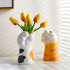 two vases with flowers in them on a table