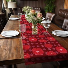 the table is set with flowers in vases and place settings for two people to sit at