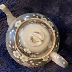 a tea pot filled with white liquid on top of a blue blanket