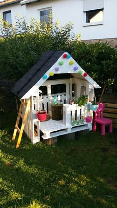 a little house made out of pallets and some plants