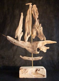 a sculpture made out of driftwood on a black background