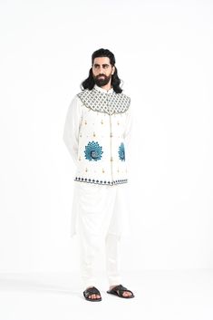 A dewy mist coloured Rajasthani inspired peacock motif hand embroidered nehru jacket with a cowl draped kurta made of bamberg raw silk. Paired with white slim fit Pant Pajama. Color of the actual garment may vary due to lighting conditions during the shoot.

Size Chart For Men





	
	
					Men's Size Chart
		

		
		
						
				Size Chart For Men
				Custom Size Measurement Guide
			
			
				
				
				Custom Size Measurement Guide
1. Take your measurements at ease…don’t hold your breath!
2. Be a Traditional Cotton Silk Nehru Jacket With Cutdana, Traditional Nehru Jacket In Cotton Silk With Cutdana, Traditional Nehru Jacket With Cutdana In Cotton Silk, Embroidered Cotton Silk Nehru Jacket For Eid, White Embroidered Cotton Silk Bandhgala, Embroidered White Cotton Silk Bandhgala, Cotton Nehru Jacket For Navratri Designer Wear, Embroidered Cotton Silk Nehru Jacket Fitted, Traditional Long Sleeve Nehru Jacket In Cotton Silk