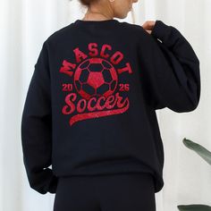 Customize these Soccer tees & sweaters with your mascot's name, team colors, then on the sleeve is the player's first name, and then finally on the front is the player number. Spirit wear makes a great gift for school teams, coaches, soccer players, moms, dads, girlfriends, or the whole family. To add lounge pants, expedite processing, add overnight shipping, and any other miscellaneous items- please follow this link: https://www.etsy.com/shop/KASPDesign?ref=seller-platform-mcnav§ion_id=27547745 The listing is for one garment. To order... 1. Select the style and size you would like, then the color for the garment. 2. Fill out the personalization section. 3. Then add to cart. To order more than one item of the same style, size, and color increase the quantity in your cart. 4. To make multip Black School Spirit Sweatshirt For Sports, Black Long Sleeve Sweatshirt For School Spirit, Team-colored Long Sleeve School Spirit Sweatshirt, Team-colored Long Sleeve Sweatshirt For School Spirit, Long Sleeve T-shirt For Sports With School Spirit, Collegiate Long Sleeve Sweatshirt Fan Merchandise, Black Long Sleeve Team Spirit Sweatshirt, Sporty Long Sleeve Mascot Sweatshirt, Long Sleeve Sweatshirt For Football Season Streetwear