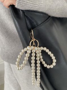 Introducing the Fonda Keychain, an elegant accessory featuring a beautifully crafted ribbon charm made from chunky acrylic pearls, forming a delicate bow shape. This sophisticated design adds a refined touch to your keys, bags, or even as a chic phone accessory. The Fonda Keychain is perfect for those who appreciate a blend of classic elegance and modern style, making it an ideal statement piece for any occasion. Carry your essentials with a touch of glamour, and elevate your everyday look with Elegant Gold Bag Charm For Gift, Elegant Gold Bag Charm As Gift, Elegant Bag Charm With Lobster Clasp As Gift, Elegant Bag Charm With Lobster Clasp For Gift, Elegant Accessories, Sophisticated Design, Classic Elegance, Ring Necklace, Phone Accessories