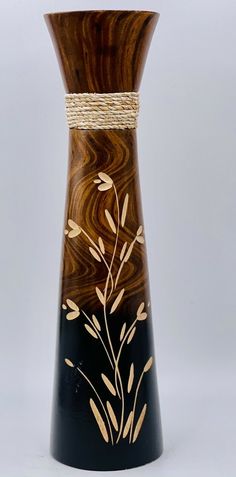 a black vase with brown and white designs on it