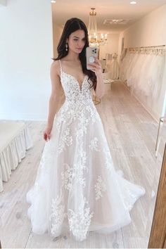 a woman is taking a selfie in her wedding dress while wearing a white gown