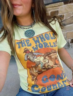 "Gear up for a wild ride with \"The Whole World's Gone Country\" Western Graphic Tee, starring a cowboy on horseback. This tee isn't just clothing; it's a statement. Embrace the rugged charm of the West with a design that captures the spirit of the Wild West." Fitted Crew Neck T-shirt For Rodeo, Western Style T-shirt For Ranch In Summer, Fitted Graphic Print T-shirt For Ranch, Western Style Summer T-shirt, Fitted Graphic Print T-shirt For Rodeo, Western Style T-shirt For Spring Ranch, Graphic Print T-shirt For Rodeo, Western Pre-shrunk Tops For Summer, Fitted Graphic Print Tops For Rodeo