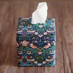 a tissue dispenser sitting on top of a wooden table