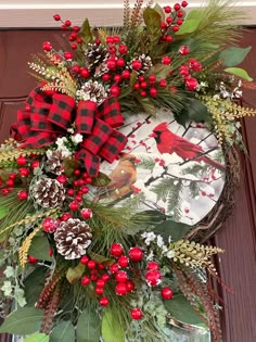 a christmas wreath with red berries and pine cones