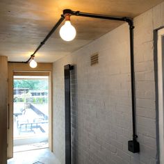 an open door leading to a patio area with a light fixture hanging from the ceiling