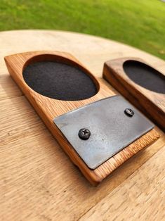 two speakers sitting on top of a wooden table next to each other in front of a grassy field