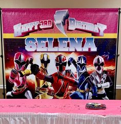 a table topped with a sign that says happy birthday stella and the power rangers on it